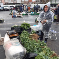 Una vendedora se protege de la lluvia en la feria de Paiosaco